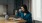 a person sitting at a table drinking from a cup
