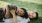 a child and woman lying in the grass