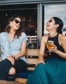 two girls laughing and drinking